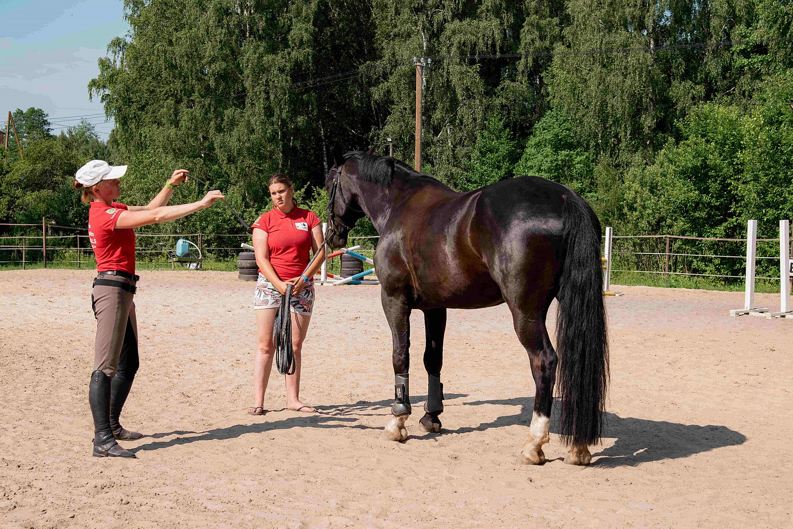 trenere Ieva Prūse dod norādījumus jātniecei, kura tur pie pavadas zirgu